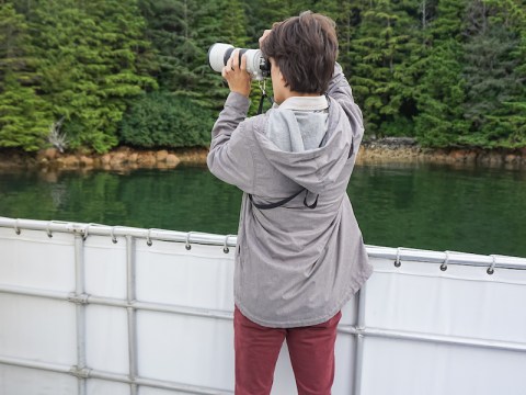 Woman taking photo from boat. Photo by Alabastro Photography.