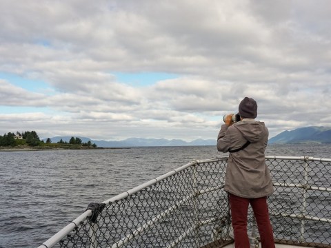 A young man pulls out his camera to photograph Guard Island Lighthouse as our tour vessel begins its approach. Photo by Alabastro Photography