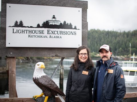 two people standing in front of a sign