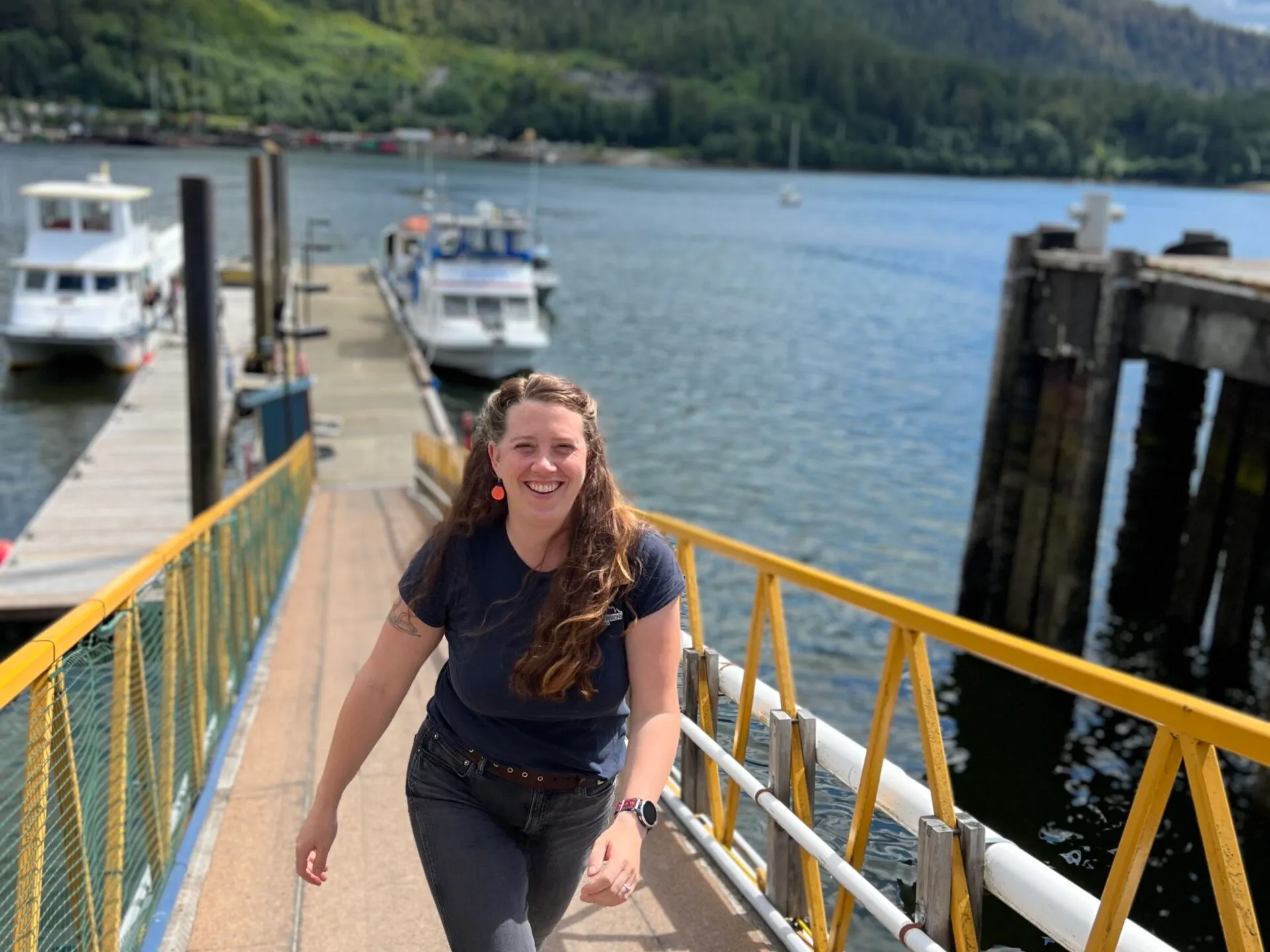 a woman standing on a dock next to a body of water