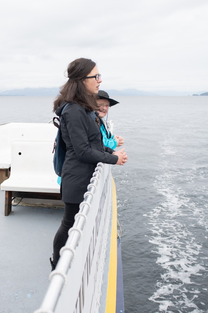 october 2023 lighthouse-185 Two people on a boat, standing by the railing, looking at the ocean.